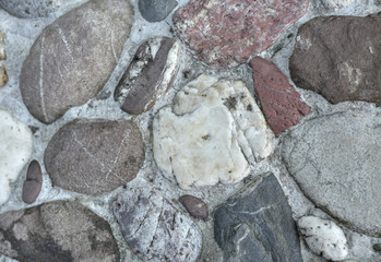Exposed gravel in natural wall background.
