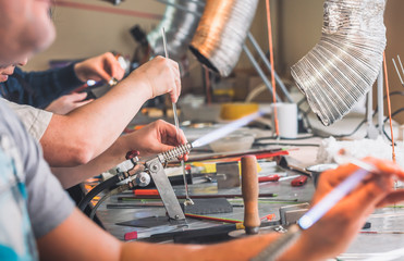 Students at work in a glass-blowing workshop. Glass on fire.