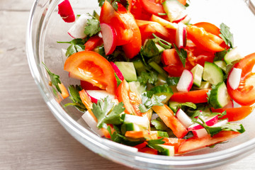 Fresh vegetable salad in a glass bowl. Tomato and cucumber salad 