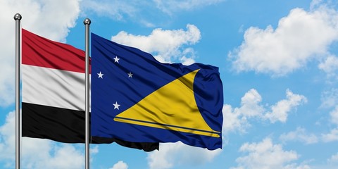 Yemen and Tokelau flag waving in the wind against white cloudy blue sky together. Diplomacy concept, international relations.