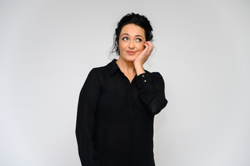 Business woman concept. Portrait of a pretty brunette woman on a white background in a black blouse. He stands in front of the camera, smiles, talks in various poses with emotions.