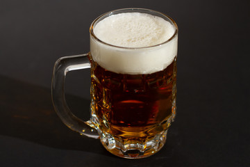 glass of beer with foam isolated on black