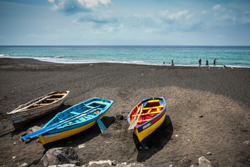 Three colorful wooden boats on a beach