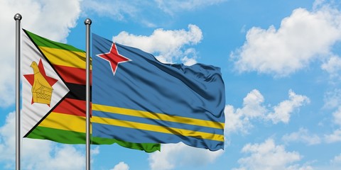 Zimbabwe and Aruba flag waving in the wind against white cloudy blue sky together. Diplomacy concept, international relations.