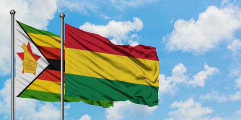 Zimbabwe and Bolivia flag waving in the wind against white cloudy blue sky together. Diplomacy concept, international relations.