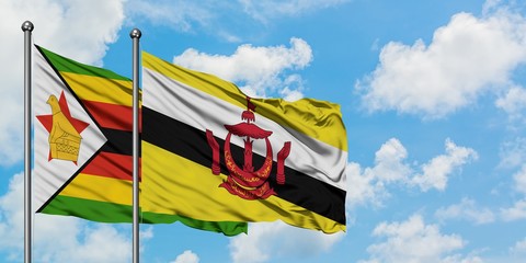 Zimbabwe and Brunei flag waving in the wind against white cloudy blue sky together. Diplomacy concept, international relations.