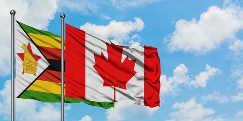 Zimbabwe and Canada flag waving in the wind against white cloudy blue sky together. Diplomacy concept, international relations.