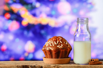 Christmas cupcake sprinkled with icing sugar on a background of the Christmas tree. Baking with rosemary, raisins. Christmas dessert on the background of a garland. A place for copywriting. New Year 2
