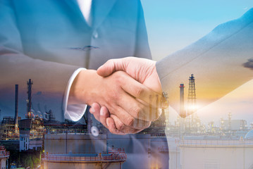 Double exposure of business handshake for successful of investment deal and oil and gas refinery...