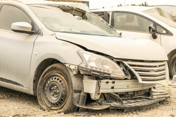 a vehicle wrecked and burnt and became unrecognizable in heavy road accident and parked outdoor with other cars