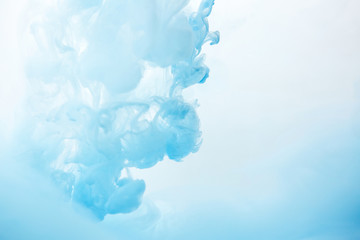 Abstract flowing liquid or blue ink in water on a white background. It looks like smoke or cloud. Or zero gravity.