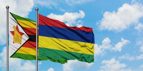 Zimbabwe and Mauritius flag waving in the wind against white cloudy blue sky together. Diplomacy concept, international relations.