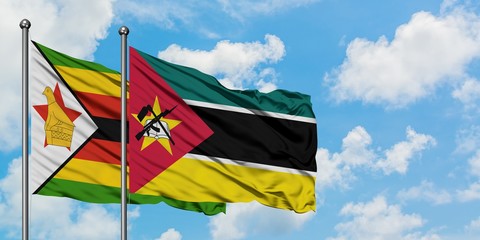 Zimbabwe and Mozambique flag waving in the wind against white cloudy blue sky together. Diplomacy concept, international relations.
