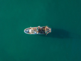 Aerial view of fishing boat anchored on ocean. Peaceful scene on water. Concept of traditional fishing in Europe.