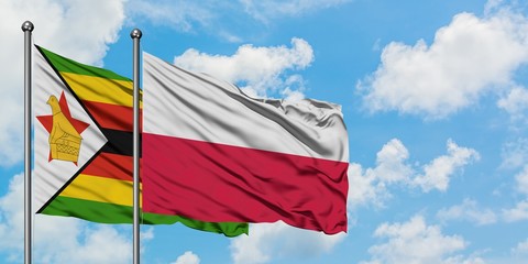 Zimbabwe and Poland flag waving in the wind against white cloudy blue sky together. Diplomacy concept, international relations.