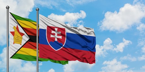 Zimbabwe and Slovakia flag waving in the wind against white cloudy blue sky together. Diplomacy concept, international relations.