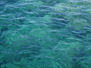 Fototapeta na wymiar Water surface of mediterran sea. Sea floor visible through waves. Concept of clean water.