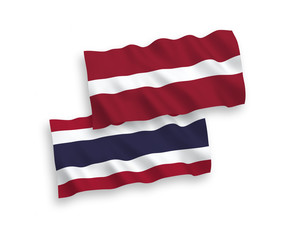 National vector fabric wave flags of Latvia and Thailand isolated on white background. 1 to 2 proportion.