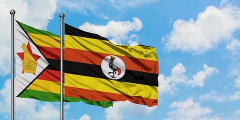 Zimbabwe and Uganda flag waving in the wind against white cloudy blue sky together. Diplomacy concept, international relations.