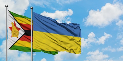 Zimbabwe and Ukraine flag waving in the wind against white cloudy blue sky together. Diplomacy concept, international relations.