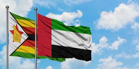 Zimbabwe and United Arab Emirates flag waving in the wind against white cloudy blue sky together. Diplomacy concept, international relations.