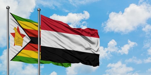Zimbabwe and Yemen flag waving in the wind against white cloudy blue sky together. Diplomacy concept, international relations.