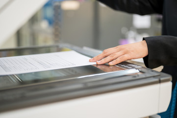 The female staff is copying the photocopier in the office.