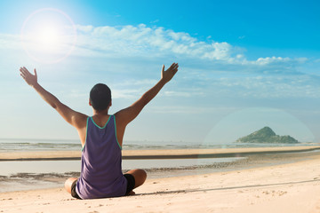 man practicing yoga on the beach