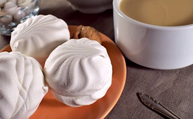 marshmallows on a beige plate, which stands on a brown tablecloth