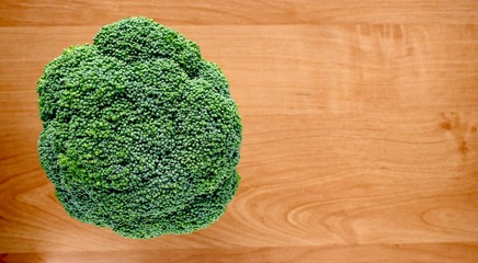 head of broccoli on an alder wooden stand