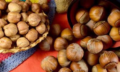 peeled and inshell hazelnuts on a red countertop