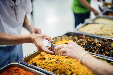 Volunteers provide free food to the poor with care : concept of begging for food