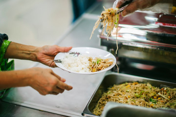 Volunteers provide free food to the poor with care : concept of begging for food