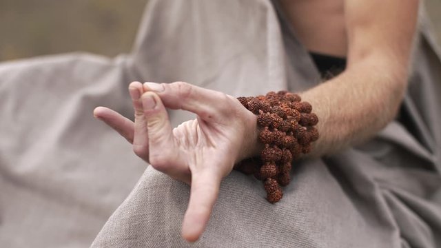 Hand of meditating yogi on nature