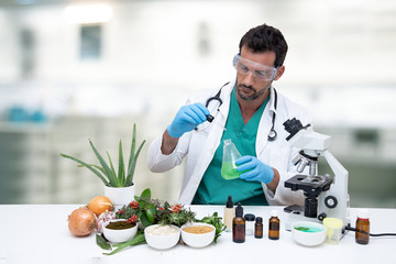 scientific doctor in the laboratory, analyzing herbs and medicinal plants, next to a microscope