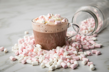 Heiße, dunkle Trinkschokolade mit Sahne und Marshmellows auf Marmor hell Hintergrund 