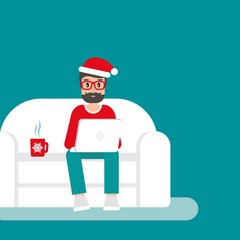 happy freelancer man with santa hat on sofa with laptop. creative hipster work at home.