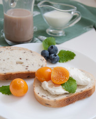 bread sandwiches with cream cheese and cocoa physalis berries and milk in the background