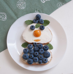 white bread sandwiches with cream cheese and blueberries as a snowman