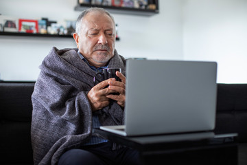 A senior businessman working at home office when he is flu and cold