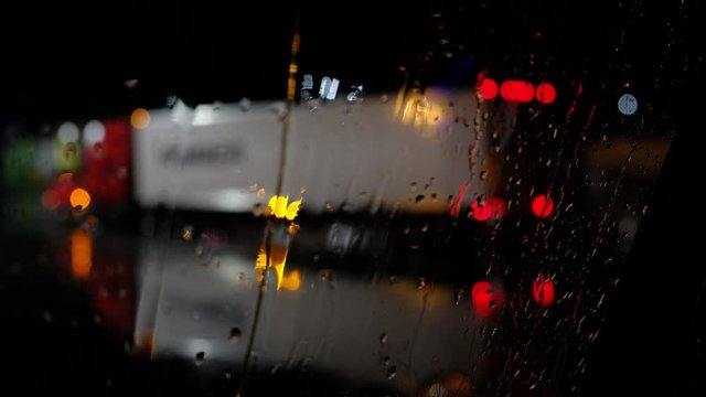 Semi Truck Backing Up, Seen Thru A Wet Windshield At Night While Raining. Lorry Delivering