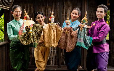 Team Asian People or Traditional Thai Puppet Theater of Arts and culture concept. Group of Asian Puppet show join hand holding Traditional Thai style puppet dolls with elegant costume, character