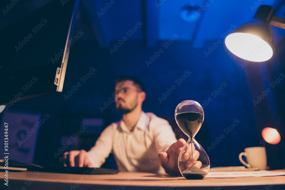 Poster close up photo of hourglass counting time deadline with business man trying to fulfill all of his as