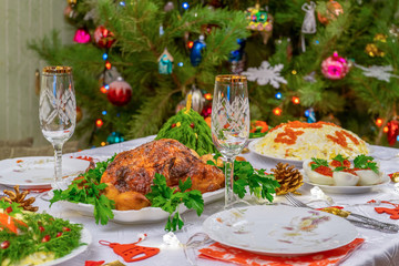 Festive Christmas served table against beautiful green pine tree decorated with many colorful new year toys. Xmas dinner, delicious food, christmas turkey. Winter holidays celebration at cozy home
