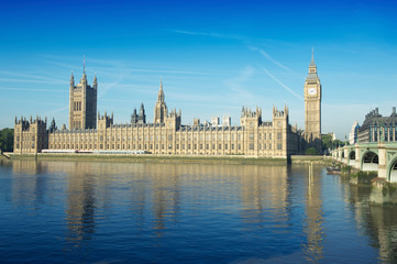 Fototapeta na wymiar Scenic view of Big Ben and the Houses of Parliament at Westminster Palace with the arches of the nearby bridge over the River Thames in London, UK