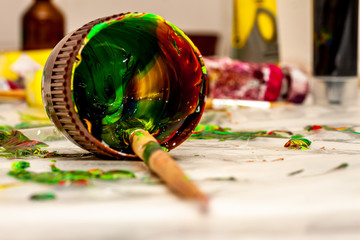 Close up of liquid artist colours on brush and pot