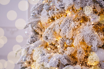 Christmas white tree decorated snow illumination and gifts toys, background light bokeh, silver color