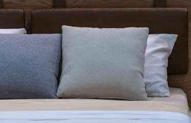Modern gray fabric pillows with brown leather headboard on the bed interior decoration