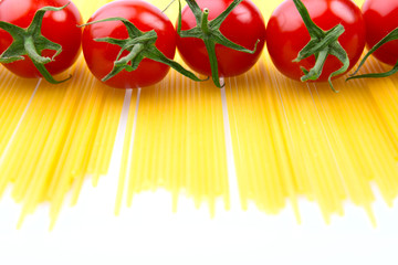 rohe Spaghette und Tomaten in einer Reihe