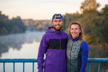 Young smiling couple standing on the bridge